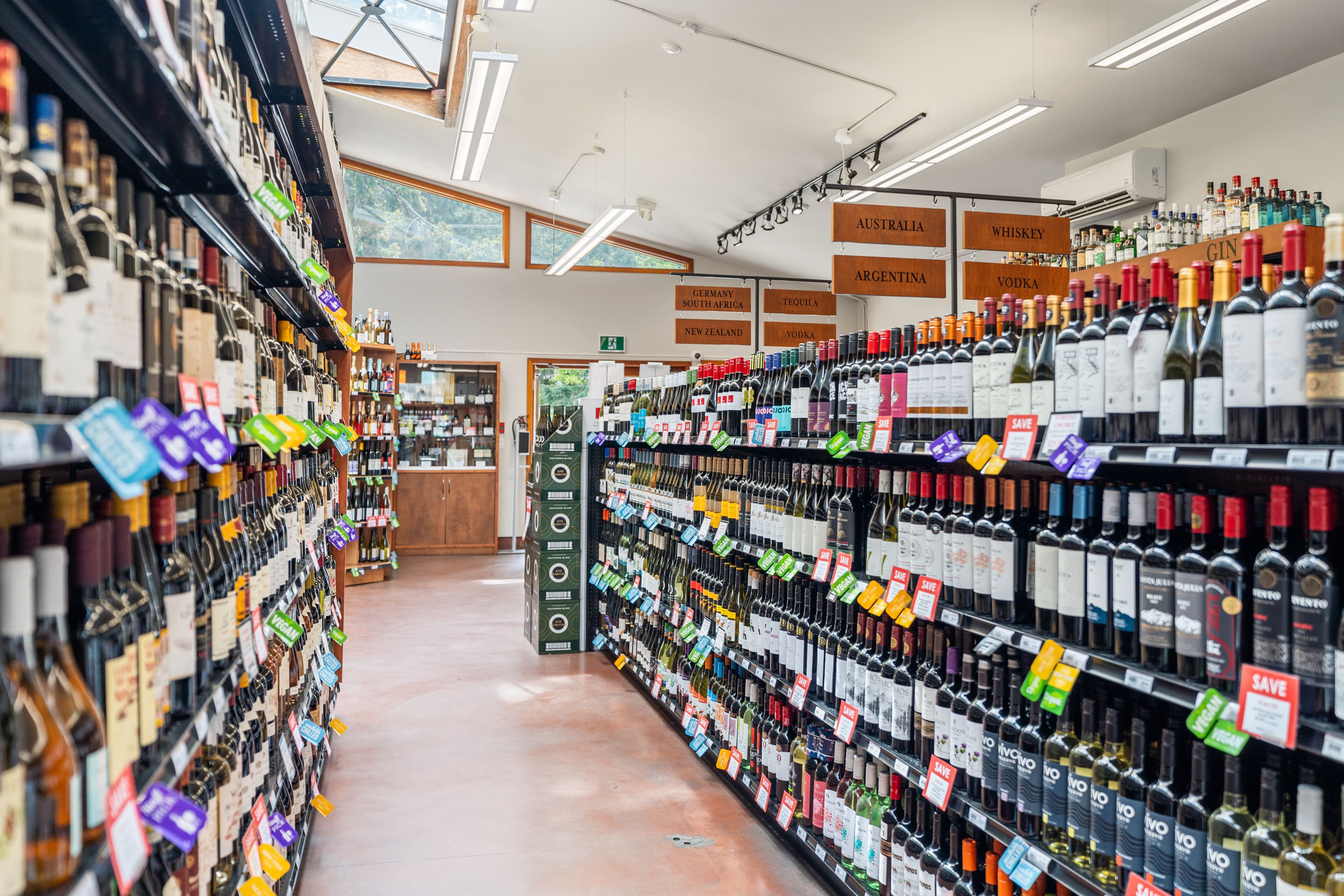 Liquor Plus interior with Chilled Products signage and prosecco/champagne wall