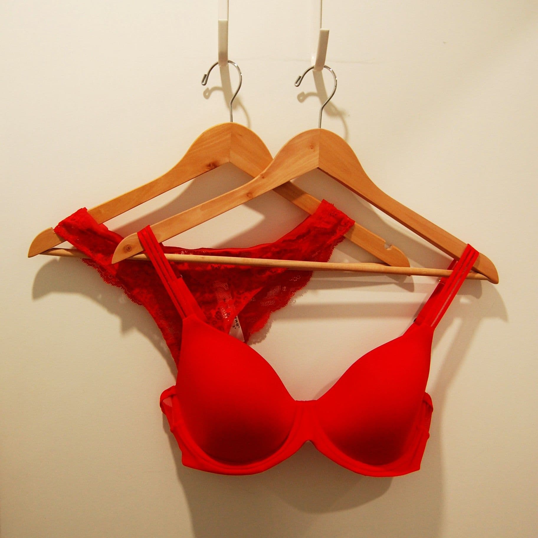 Red bra and matching lace on wooden hangers