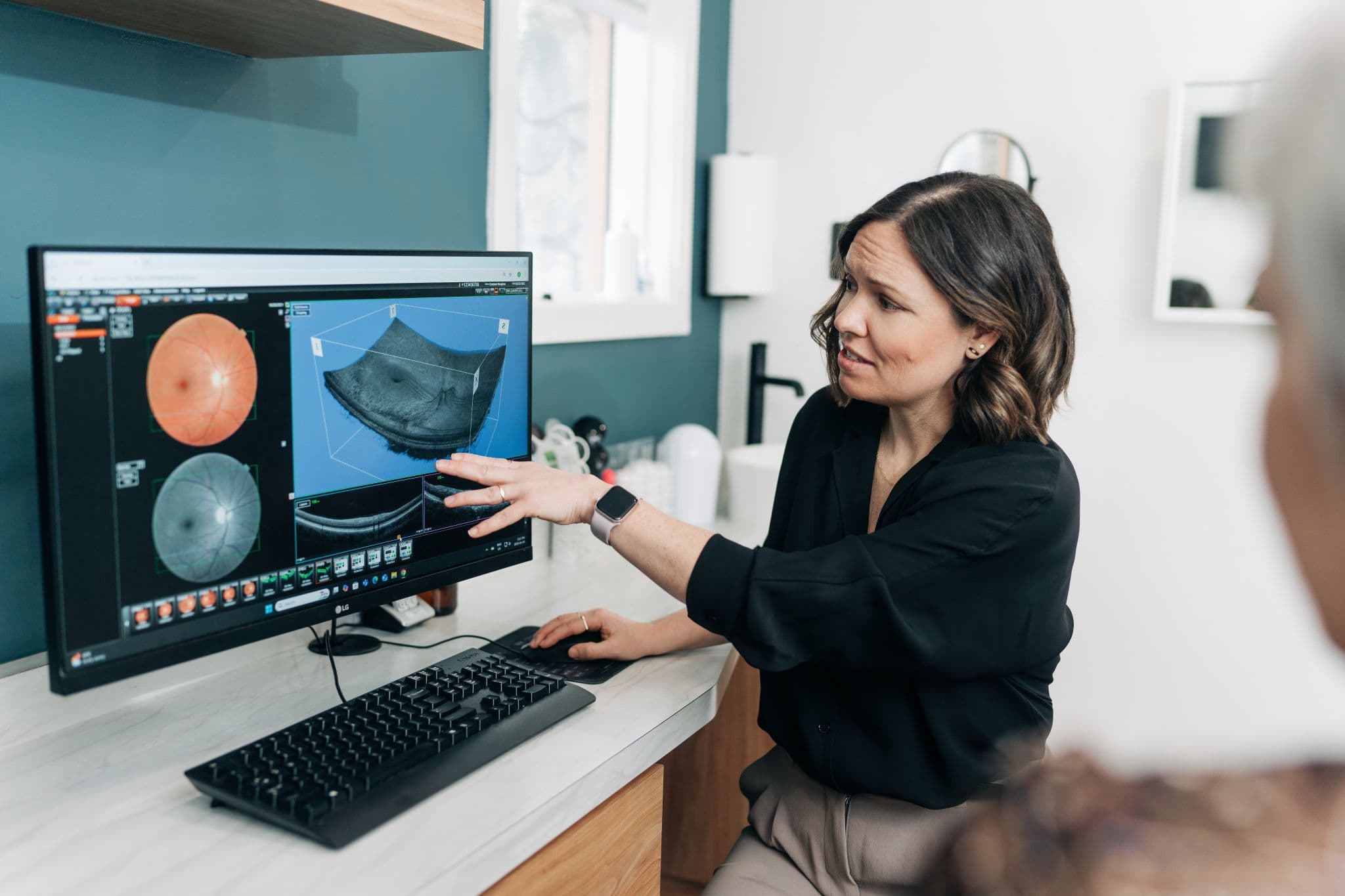 Optometrist reviewing a retinal scan on a monitor