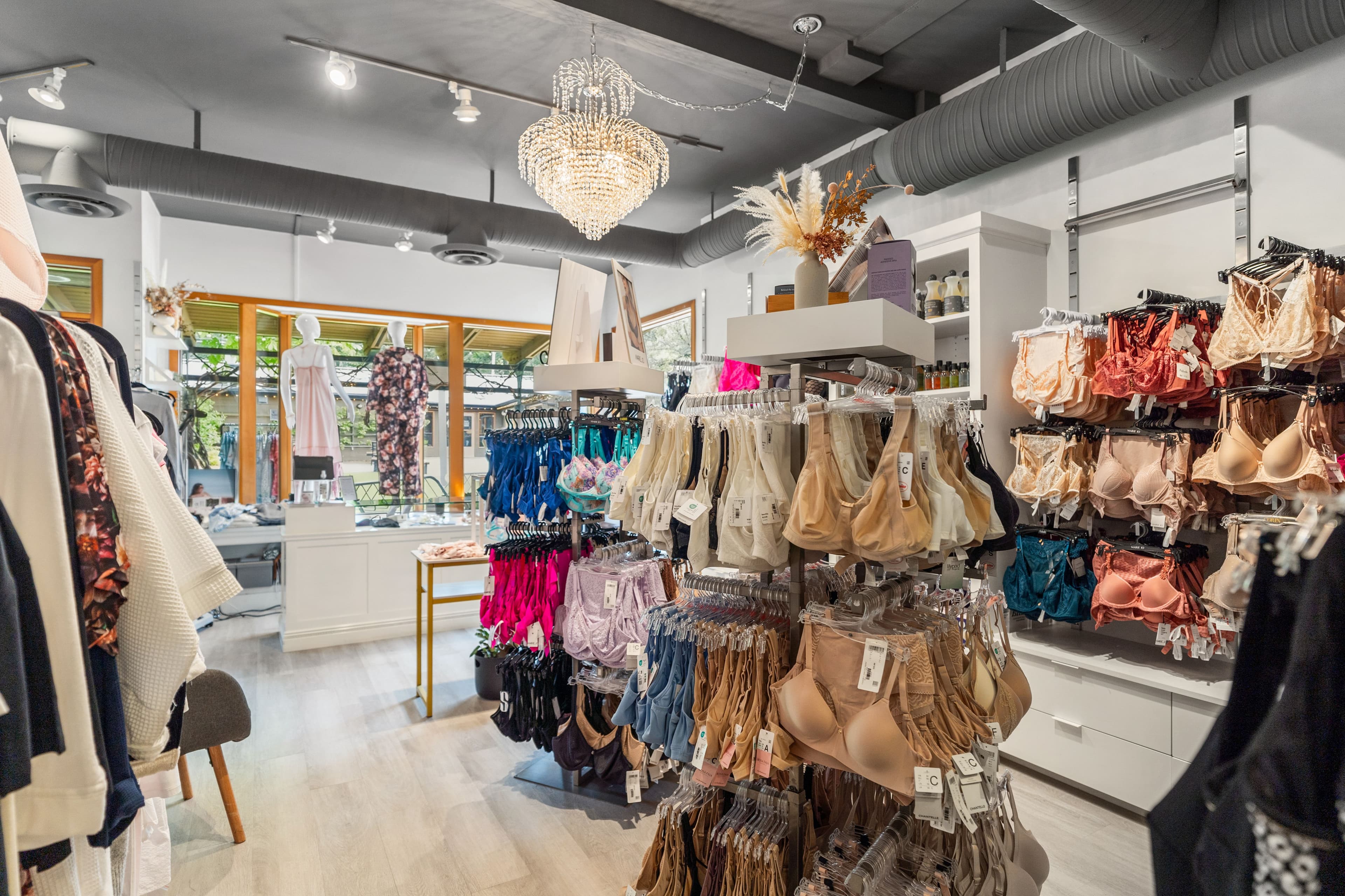 Wide view of the boutique with chandelier, garments and bra wall