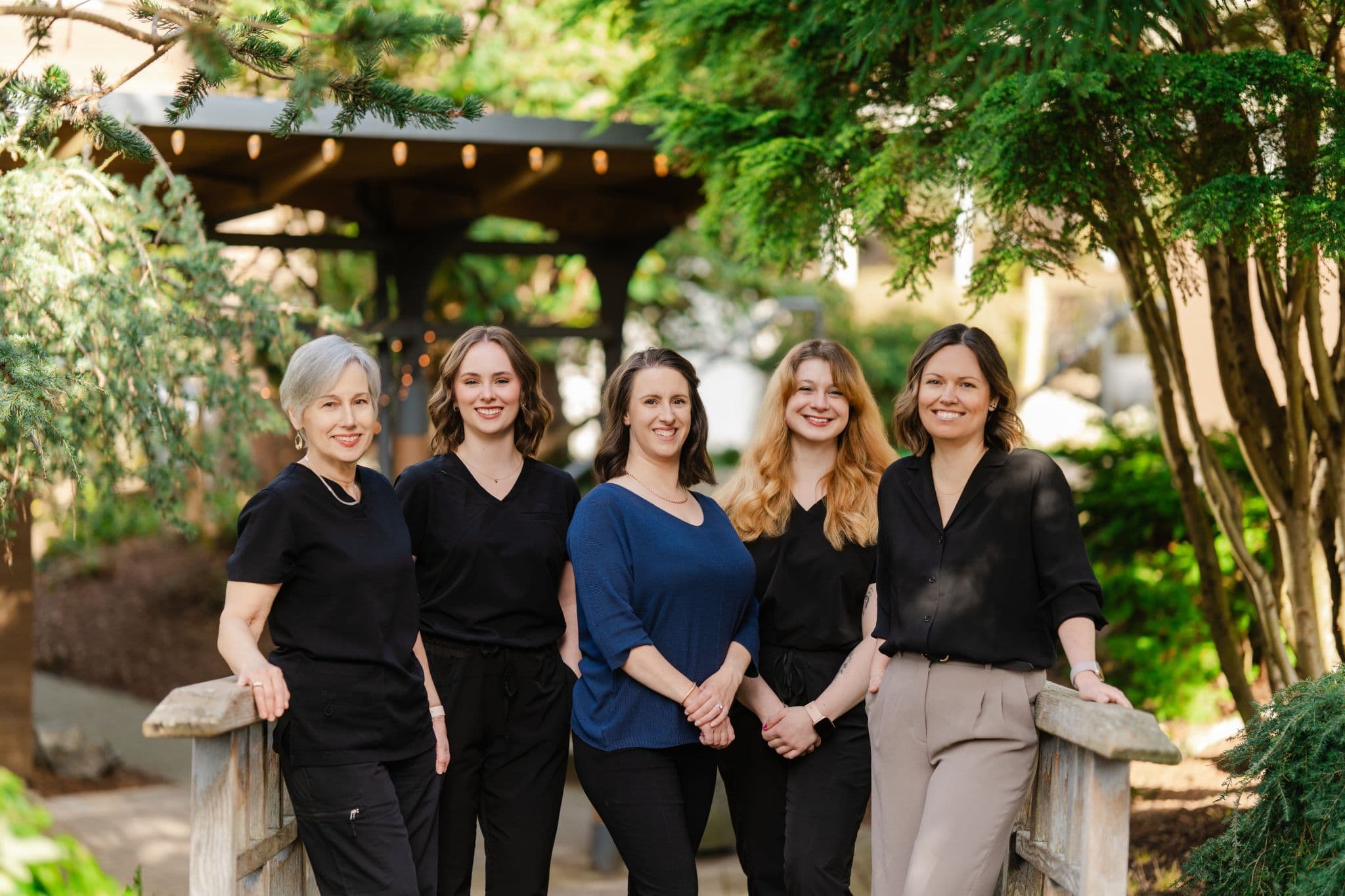 The Cordova Bay Optometry team outdoors under a wood pavilion